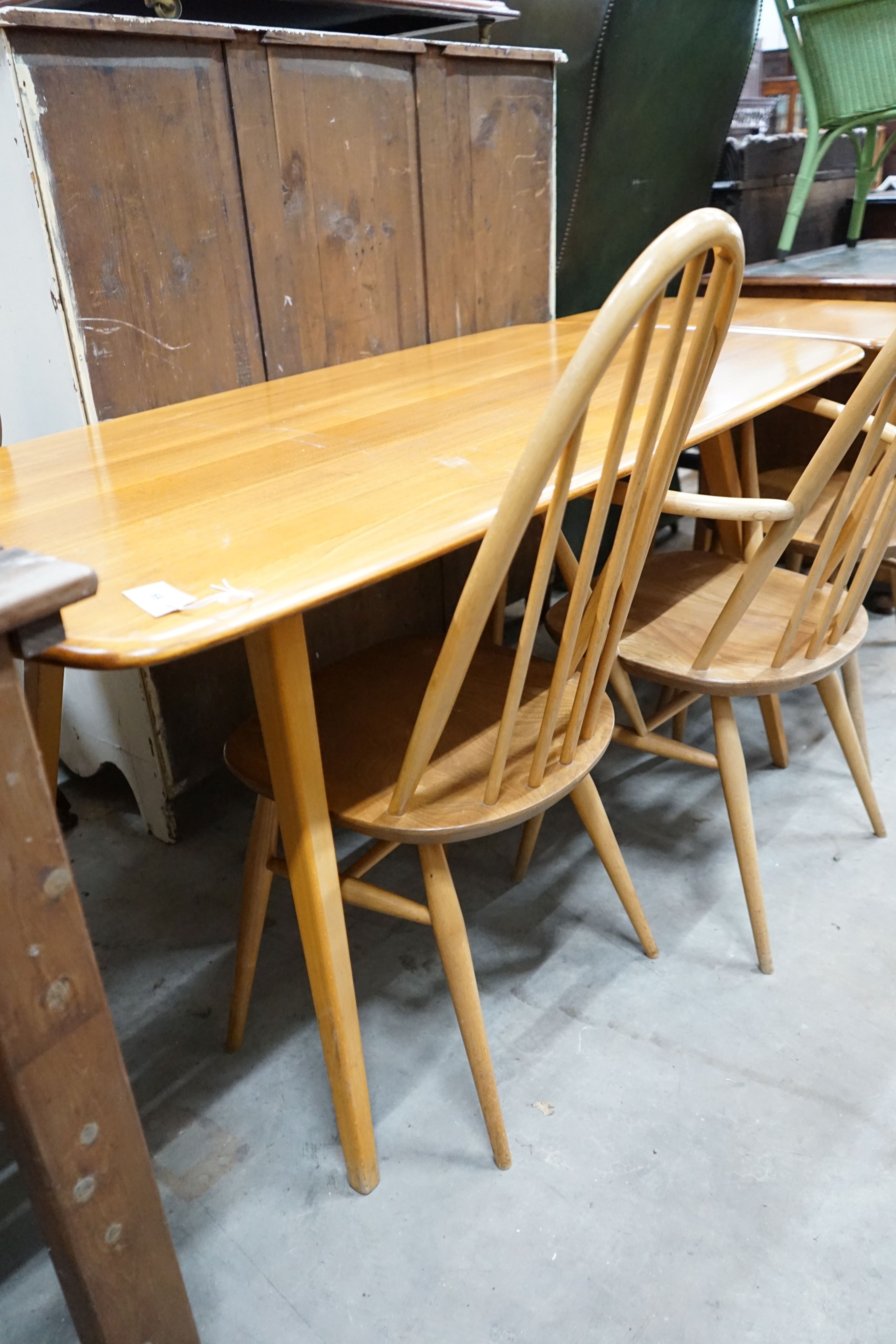 An Ercol rectangular light elm dining table with extension section, length 150cm, depth 76cm, height 72cm and three Ercol elm and beech comb back chairs, one with arms